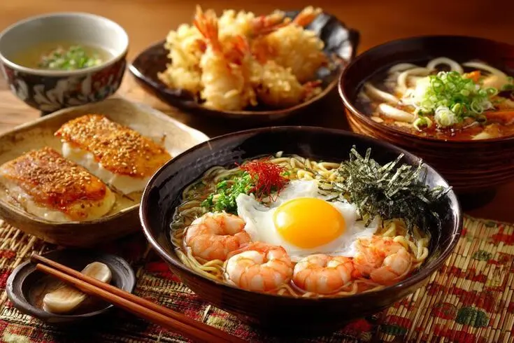 天ぷらや海老をのせた麺料理が並ぶ食卓