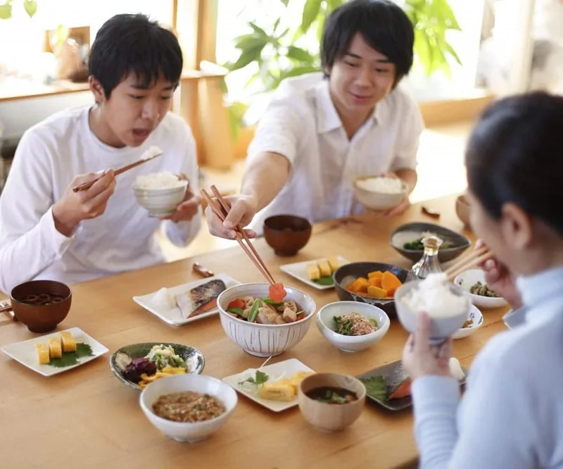 ご飯や味噌汁、小鉢が並ぶ朝の食卓を囲む家族