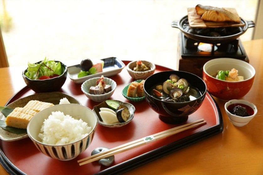 焼き網の魚とご飯、小鉢を並べた朱塗りの膳
